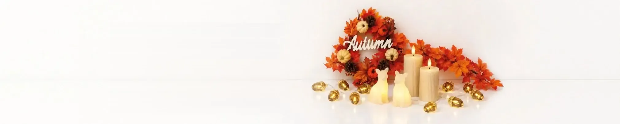 Herbstkranz aus Ahornblättern, Kürbisse, Kerzen und Lichterkette mit Eicheln