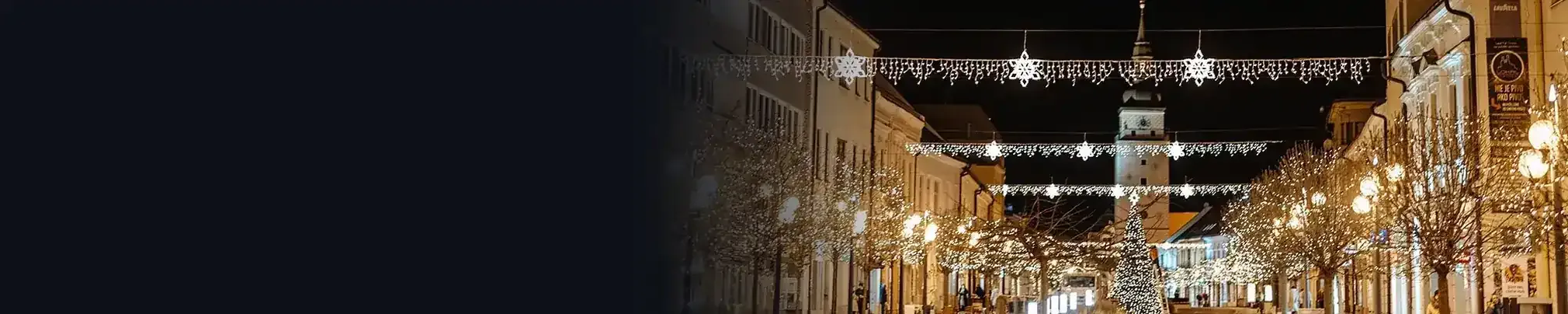 Nächtliche Straße mit weihnachtlicher Lichtdekoration über der Straße und an den Masten