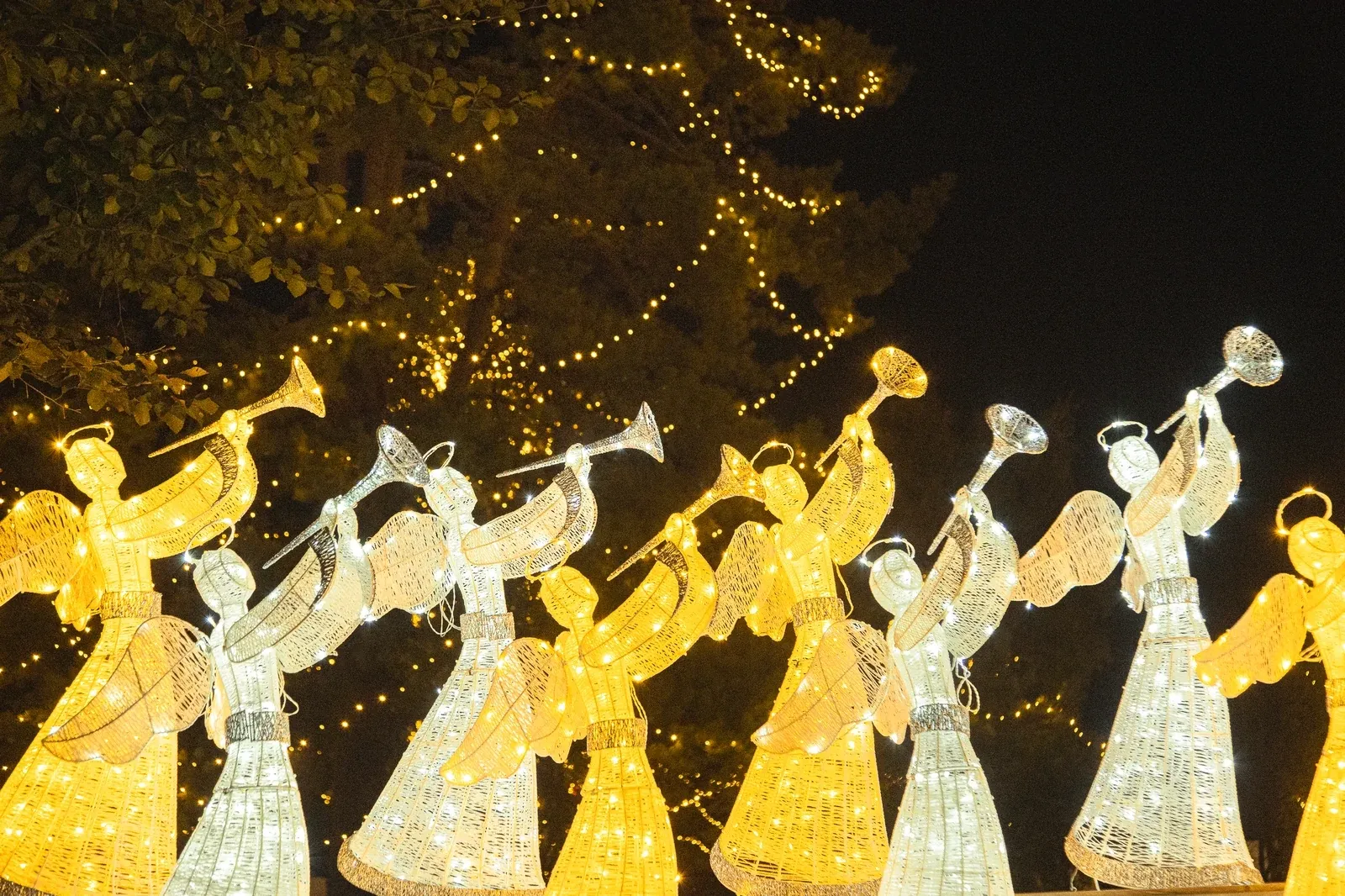 Reihe warmweißer LED-Engel mit Trompete 122 cm im nächtlichen Lichterpark am Schloss Gödöllő, 2025